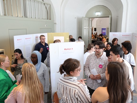 Personer minglar och pratar motioner på Röda Korsets Ungdomsförbunds Riksårsmöte.