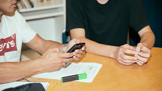 Person får läxhjälp av Röda Korsets Ungdomsförbund.