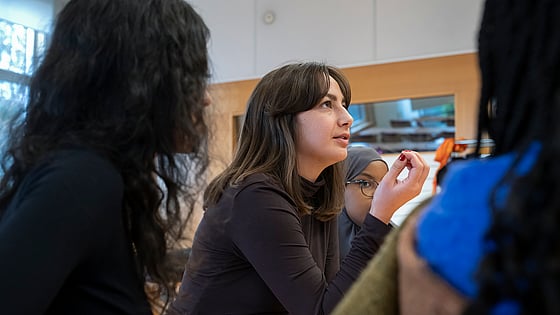 Person som är aktiv i Röda Korsets Ungdomsförbund sitter och diskuterar med andra