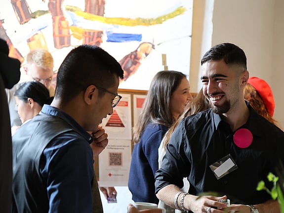 Två personer pratar och skrattar på Röda Korsets Ungdomsförbunds Riksårsmöte.