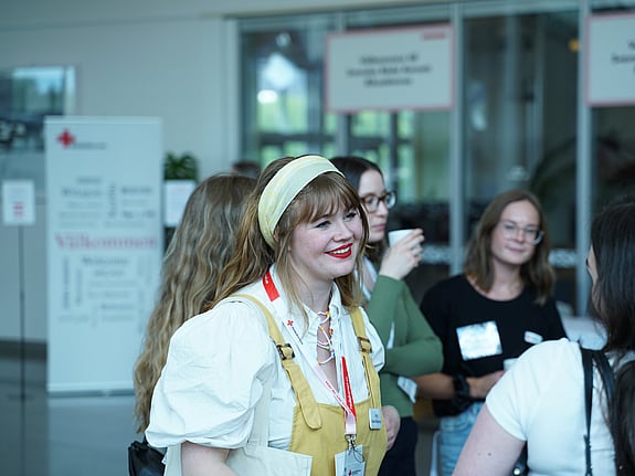 Bild på personer som skrattar på Röda Korsets Ungdomsförbunds årliga Riksårsmöte.