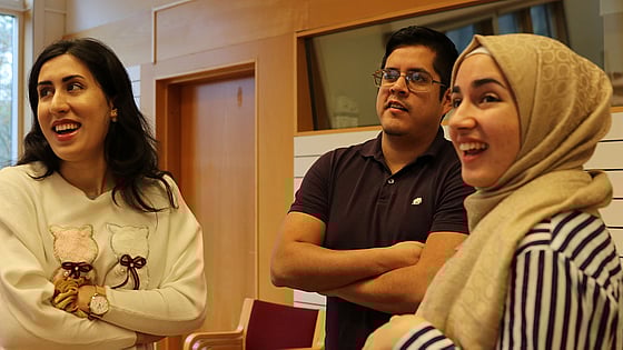 Tre unga personer står och pratar på MOVE